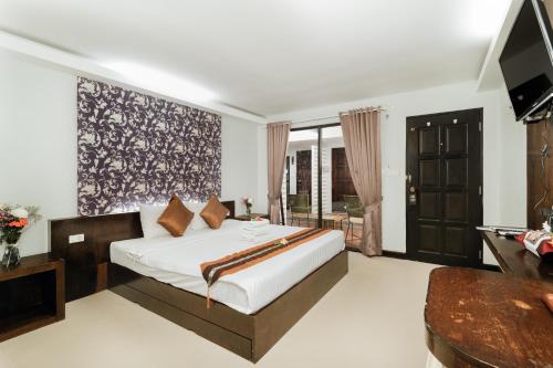 a bedroom with a large bed and a television at Ibiza House Phi Phi in Phi Phi Don