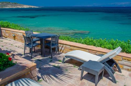 a patio with a table and chairs and the ocean at Plaka Studios in Karfas