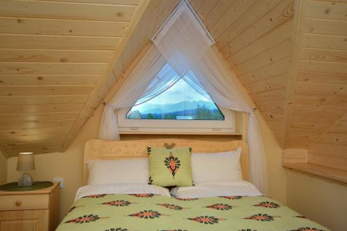 a bedroom with a bed with a window at Sykowny in Zakopane