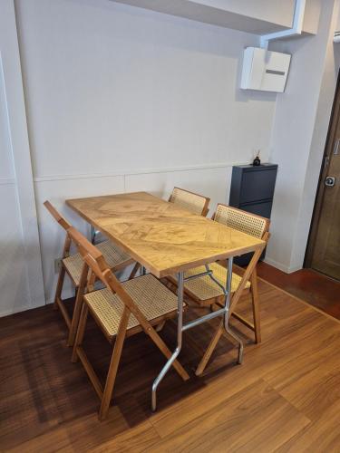 a wooden table and chairs in a room at TABiTO Stay Inarimachi in Toyama