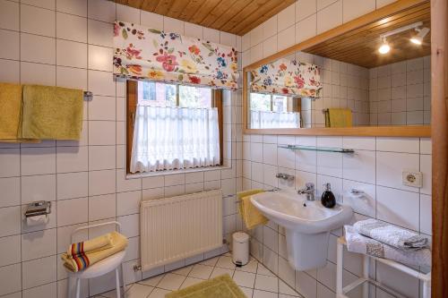 ein weißes Badezimmer mit einem Waschbecken und einem Spiegel in der Unterkunft Haus Schönblick - wunderbare Zentrumslage in Alpbach