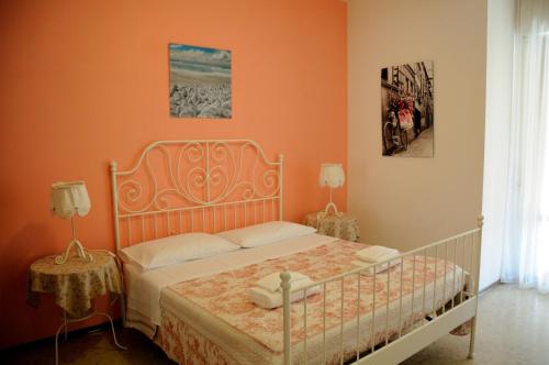 1 dormitorio con 1 cama con pared de color naranja en Sole e Sale, en San Benedetto del Tronto