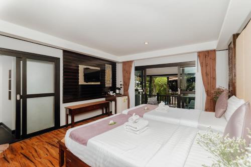 a bedroom with a large white bed and a balcony at Ibiza House Phi Phi in Phi Phi Don