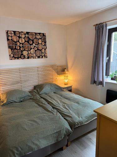 a bedroom with a bed with a wooden headboard at Gemütlicher Ferienwohnung in Niedersfeld bei Winterberg, kostenloses WLAN in Winterberg