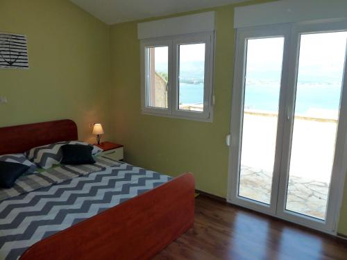 a bedroom with a bed with a view of the ocean at Apartments Tamaris in Trogir