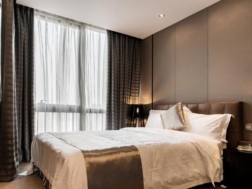 a bedroom with a large bed and a large window at Pengman Beijing Road A-mall Apartment - Free Shuttle to Canton Fair in Guangzhou