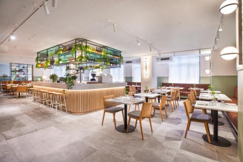 a restaurant with tables and chairs and a bar at Holiday Inn Melbourne Bourke Street Mall by IHG in Melbourne