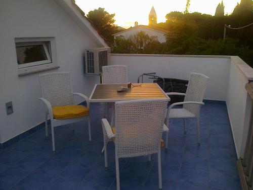 a wooden table and chairs on a patio with a table and chairs at Apartman Pašman K.B.168 in Pašman