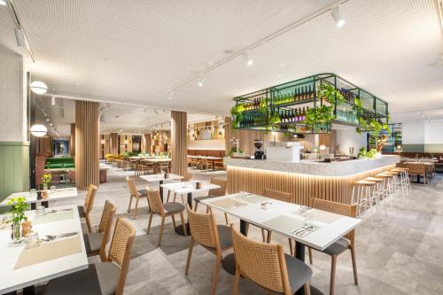 a restaurant with tables and chairs and a bar at Holiday Inn Melbourne Bourke Street Mall by IHG in Melbourne