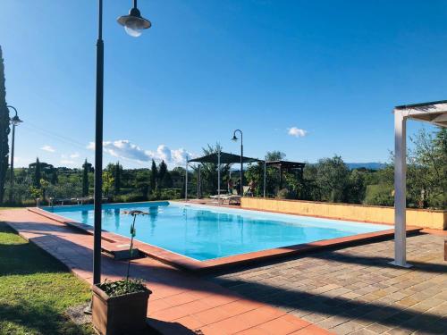 a large swimming pool with blue water in a yard at Agriturismo La Pineta in Fucecchio
