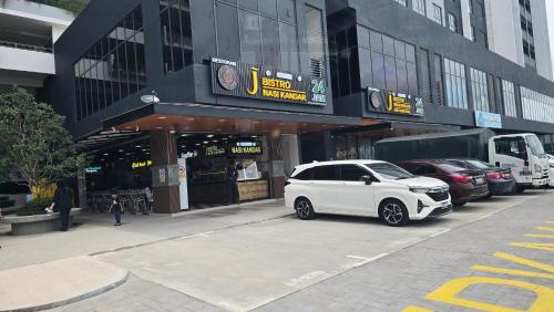 a white car parked in front of a building at Mia Casa Maya Bay Splashmania KLIA in Pulau Kempas