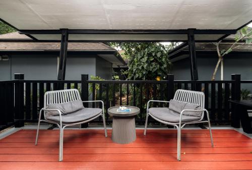 two chairs and a table on a deck at Ibiza House Phi Phi in Phi Phi Don