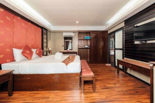 a bedroom with a bed and a television and a piano at Ibiza House Phi Phi in Phi Phi Don