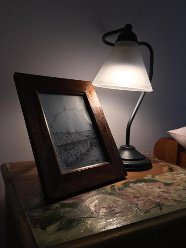 a table with a lamp and a picture of a ship at Restauracja Pensjonat Buda in Krosno