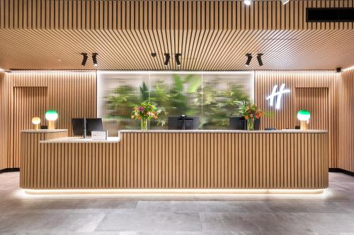 a lobby with a wooden wall with a reception desk at Holiday Inn Melbourne Bourke Street Mall by IHG in Melbourne