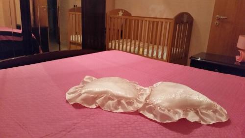 a white dress laying on a pink bed at B&B RoMa Atella in Atella