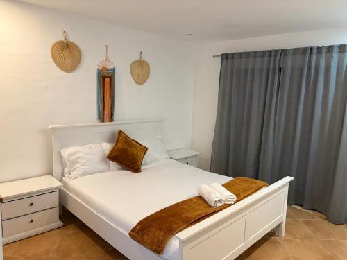a bedroom with a white bed with a brown blanket at Dave Place - 3 Bedroom House in Alte