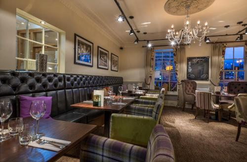 a restaurant with tables and chairs and a chandelier at The Kings Head Hotel, Richmond, North Yorkshire - The Coaching Inn Group in Richmond