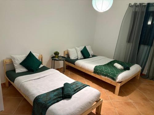 two beds are sitting in a room with at Dave Place - 3 Bedroom House in Alte