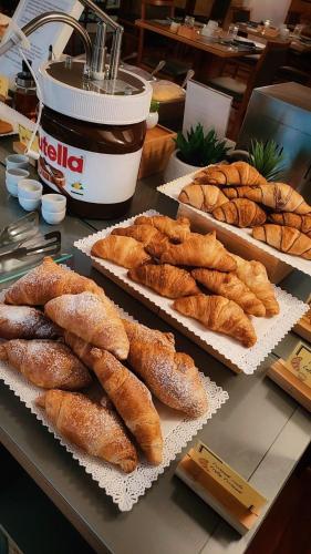a table topped with trays of bread and pastries at Euro Hotel in Nuoro