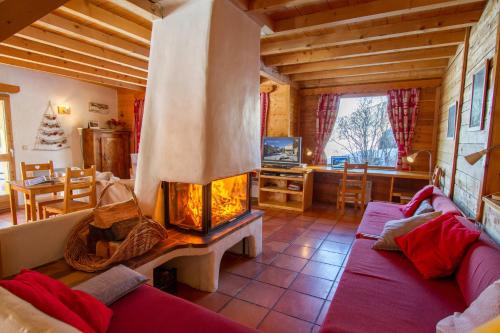 a living room with a fireplace in a cabin at Le Troll Hameau des Chazals Nevache Hautes Alpes in Névache