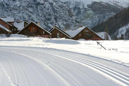 a snow covered road in front of a group of houses at Le Troll Hameau des Chazals Nevache Hautes Alpes in Névache