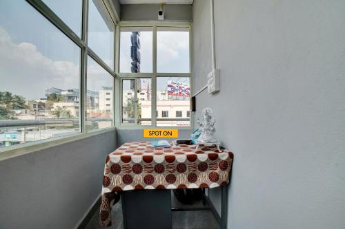 a table with a sign on it in a room with windows at Hotel O Fortuner Palace in Bengaluru