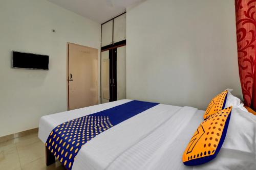 a bedroom with a bed with blue and white sheets at Hotel O Fortuner Palace in Bengaluru