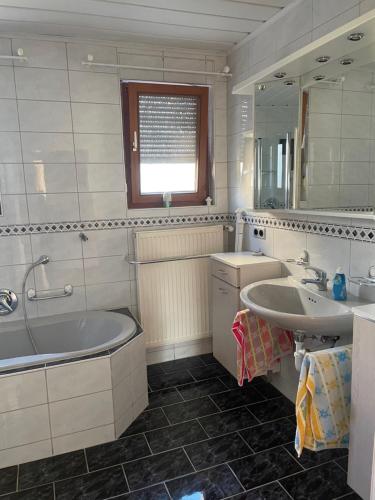 a bathroom with a tub and a sink and a mirror at Ferienwohnung Susanne in Burglengenfeld