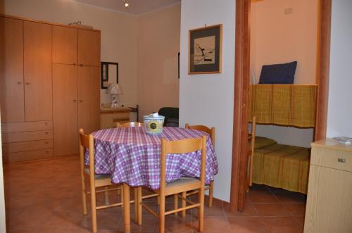 una sala da pranzo con tavolo e letto a castello di Appartamento Giardini Naxos a Giardini Naxos