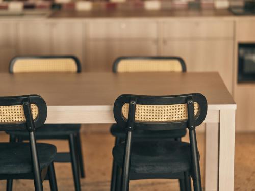 a wooden table with two black chairs around it at illi Pal Shinagawa Gotanda in Tokyo