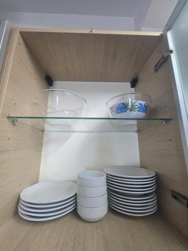 two stacks of plates and bowls on a shelf at Lazuli Sea View Beachfront- Ap 61 in Larnaca