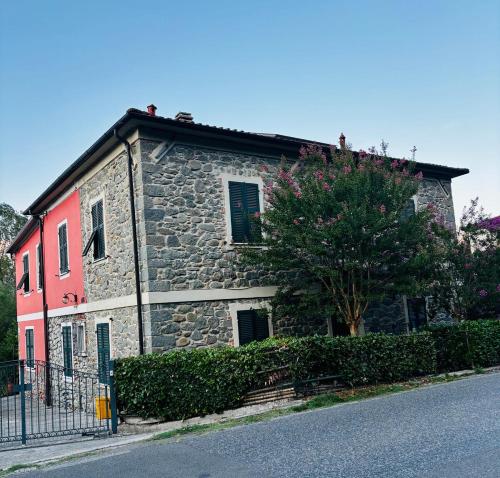 an old stone house with a tree in front of a street at La casa del marchese Malaspina in Mulazzo