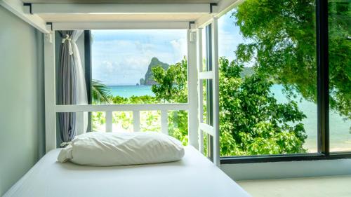 a bed in a room with a view of the ocean at Ibiza House Phi Phi in Phi Phi Don