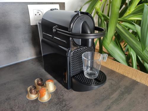 a black coffee maker sitting on a table with a glass at Appartement 2P à proximité de Strasbourg Obernai EV15 in Eschau