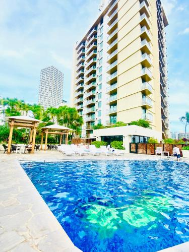 a large swimming pool in front of a tall building at Luana Waikiki hotel& suites in Honolulu