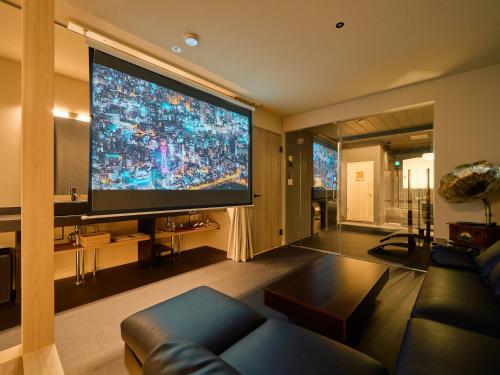a living room with a large flat screen tv at KONJAKUSO OSAKA TSUTENKAKU MUSHIBUROYA Sauna Villa in Osaka