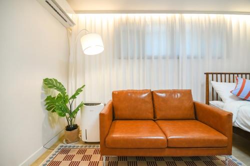 a brown leather chair in a room with a bed at Stay DAHOM2 in Seoul