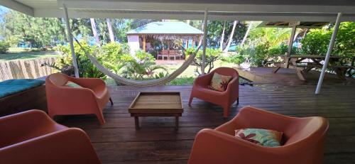 a patio with chairs and a hammock and a table at Fare Moana - Lagoon View and Serenity in Rangiroa in Avatoru