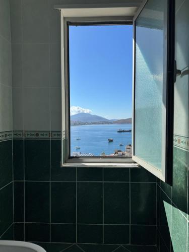 a bathroom with a window with a view of the water at Glory's Apartments Sarande in Sarandë