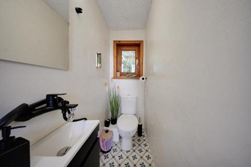a bathroom with a white toilet and a sink at Villa High Point in Pravets