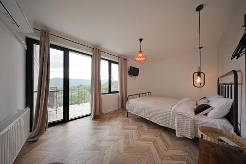 a bedroom with a bed and large windows at Villa High Point in Pravets