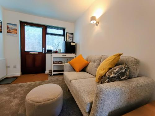 una sala de estar con un sofá y un taburete en Rosemount Guest Suite, en Grange-over-Sands