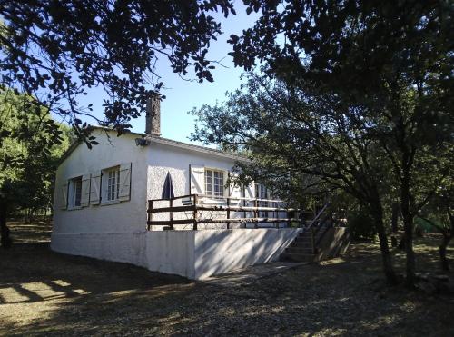 un bâtiment blanc avec une cheminée sur le dessus dans l'établissement Les Yeuses, à Brousses-et-Villaret