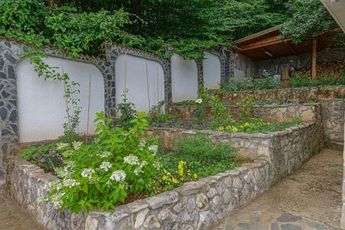 a garden with flowers in a stone wall at Villa High Point in Pravets
