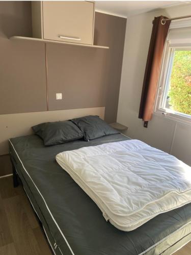 a large bed in a bedroom with a window at Chez Lulu A in Les Mathes