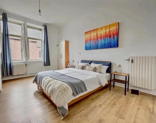a bedroom with a large bed and a painting on the wall at Station 82A Charleroi-airport in Charleroi