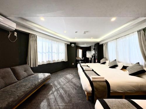 a hotel room with two beds and a couch at Oji正和ビル in Tokyo