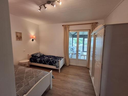 ein Schlafzimmer mit Bett und Balkon in der Unterkunft Maison de vacances 6 personnes in Saint-Hilaire-de-Riez