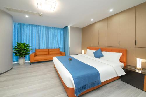 a bedroom with a large bed and an orange chair at Pengman Beijing Road A-mall Apartment - Free Shuttle to Canton Fair in Guangzhou